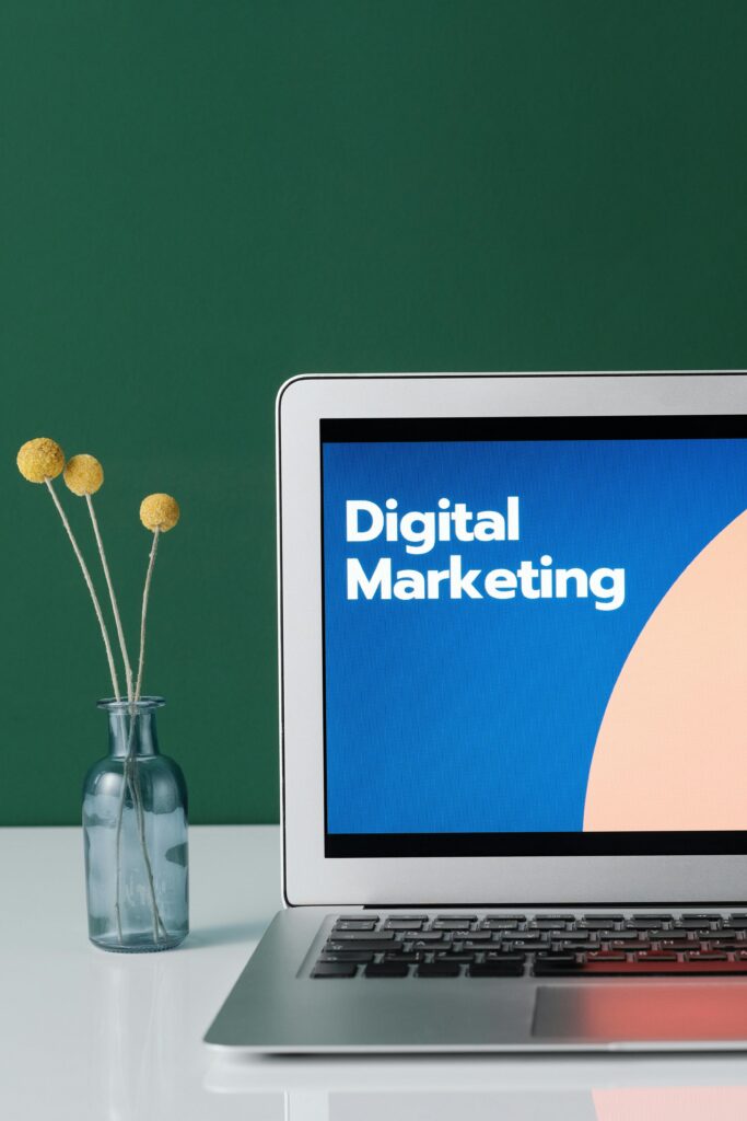 pexels photo 6483583 6483583 A laptop displaying 'Digital Marketing' with a minimalist floral decor in a glass vase.
